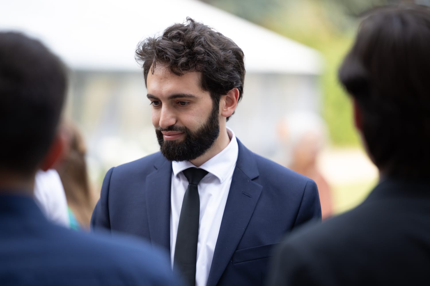 Samuel Briole in a navy suit, photographed outdoors
